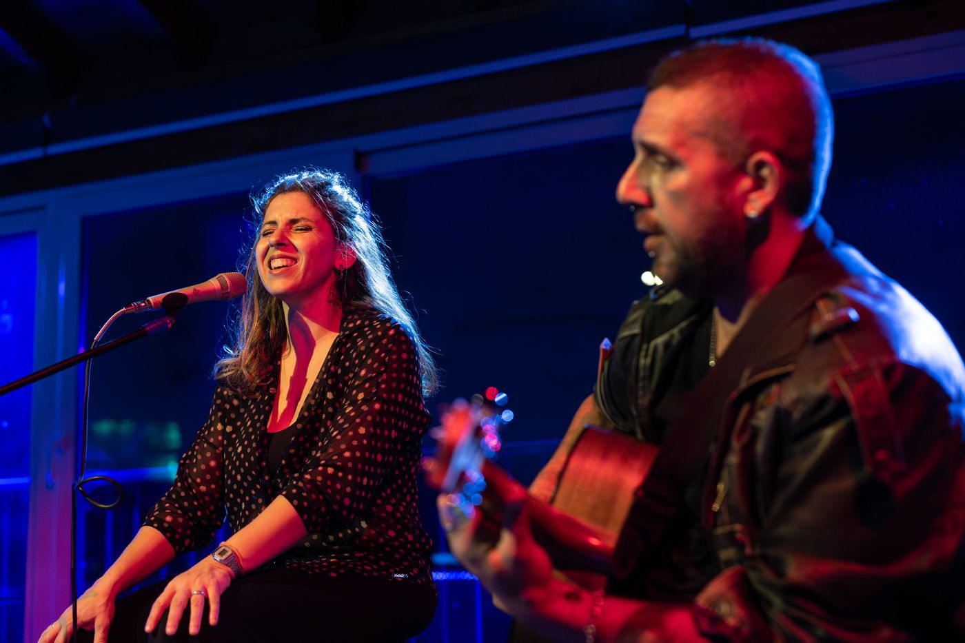 Lasimi canta seduta accanto ad Andrea Frittelli alla chitarra, luce blu
